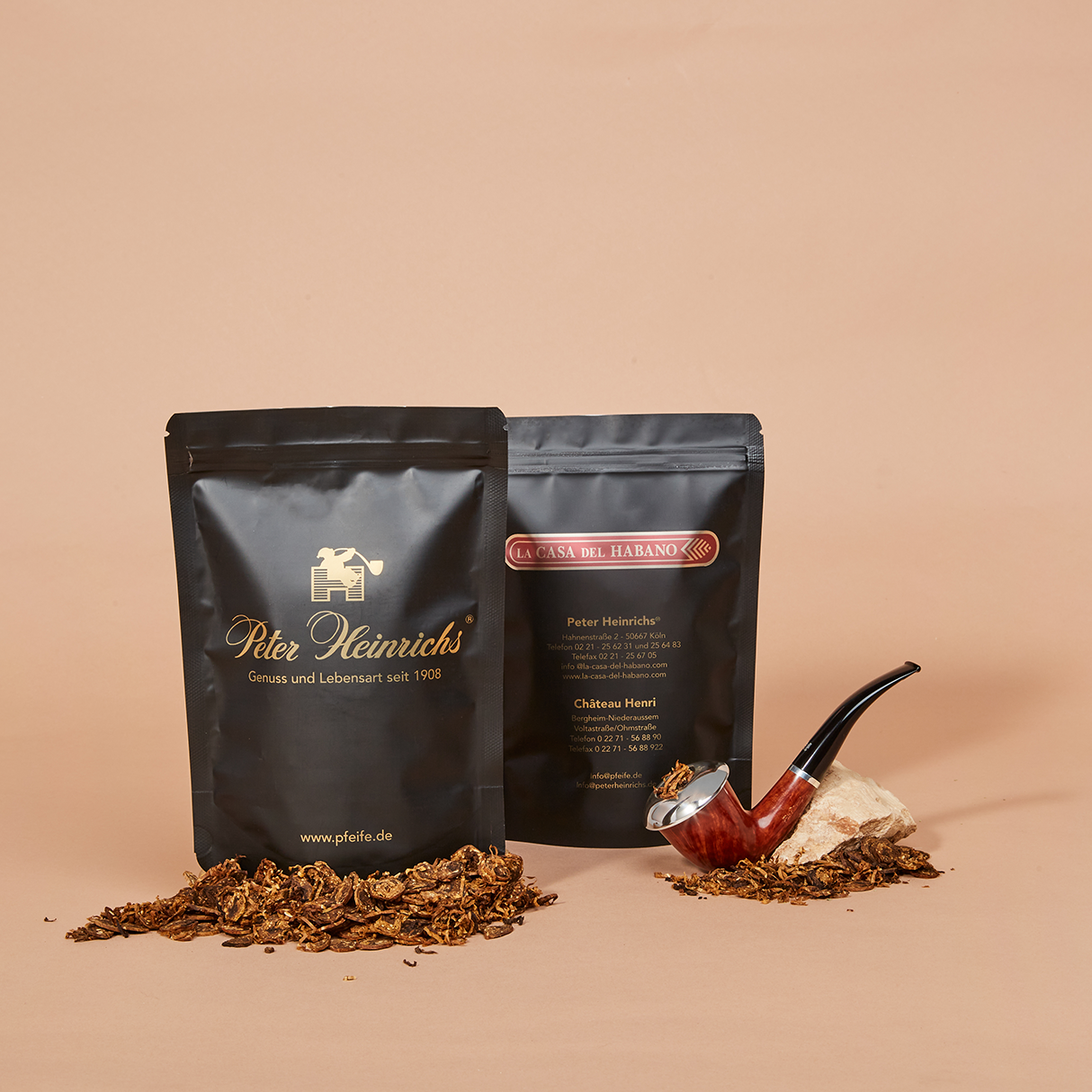 Tabakverpackungen aus Standbodenbeutel im schwarz-goldenem Design neben einer Pfeife und losem Tabak